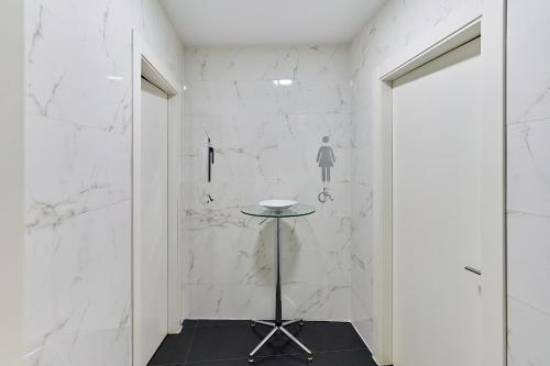a hallway with white marble walls and a table at Hotel Barrio Húmedo by gaiarooms in León