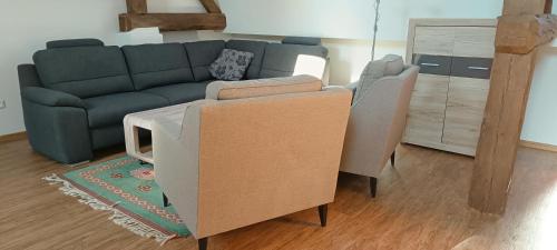 a living room with a couch and two chairs at Statek Kloubek in Chabičovice
