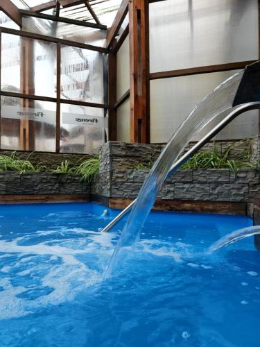 a water fountain in a swimming pool at Hotel Firenze in Necochea