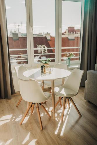 a white table and chairs in a room with a window at CityBeat Apartments, 400m from the square in Plzeň