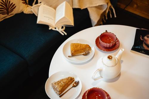 a white table with desserts and a book on it at Secret Lake Prag magic place relaxation& wellness in Řehenice