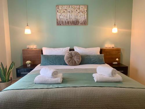 a bedroom with a large bed with towels on it at Mint Luxury Residence in Spáta