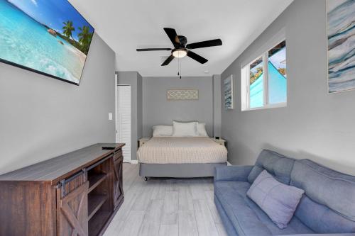 un soggiorno con ventilatore a soffitto e letto di Key Largo Home with Spa and Pool a Key Largo