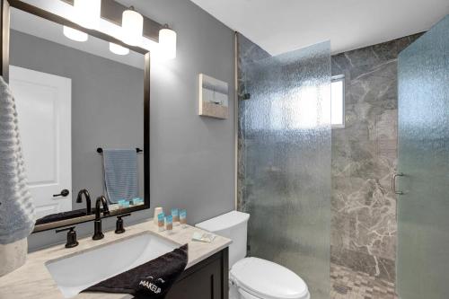 un bagno con un water, un lavandino e uno specchio di Key Largo Home with Spa and Pool a Key Largo