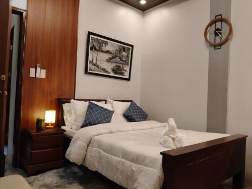 a bedroom with a large bed with white sheets and blue pillows at Goldland Caelestis Guest House in Bacolod
