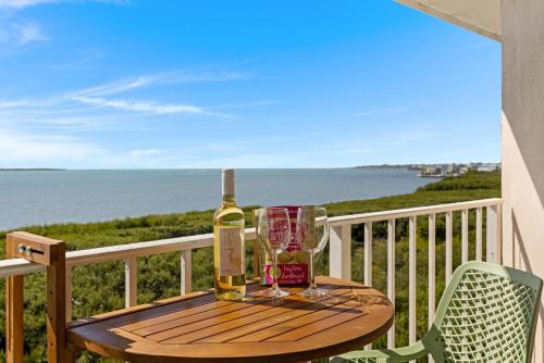 a bottle of wine and glasses on a table on a balcony at Salty Mermaid Ocean Pointe 4406 in Tavernier