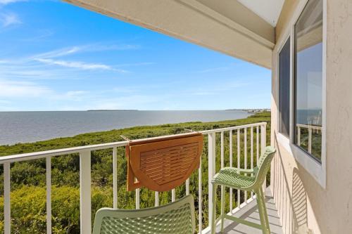 a balcony with two chairs and the ocean at Salty Mermaid Ocean Pointe 4406 in Tavernier