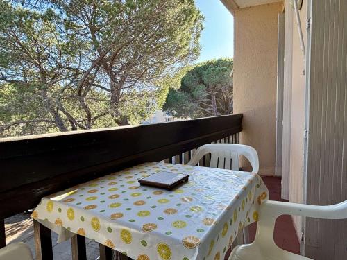 une table et des chaises sur un balcon avec une fenêtre dans l'établissement **Appartement 2 pièces à 100m de la plage avec balcon et parking - Argelès-sur-Mer** - FR-1-225-68, à Argelès-sur-Mer