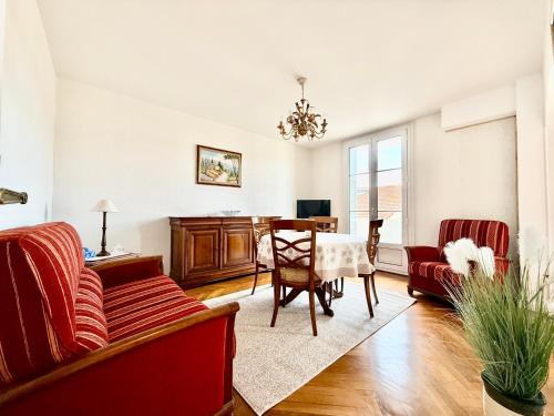un salon avec un canapé rouge et une table dans l'établissement Appartement HOCHE CANNES centre-ville, à Cannes