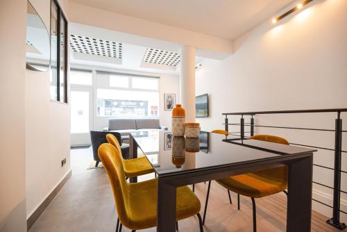 une salle à manger avec une table et des chaises jaunes dans l'établissement CIA - Grenelle Residence, à Paris