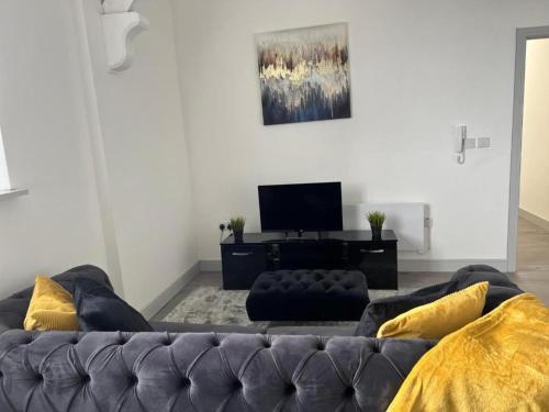 a living room with a couch and a television at 1 Bed Flat - Sleeps 2 - Pets - Parking - Wifi in Kettering