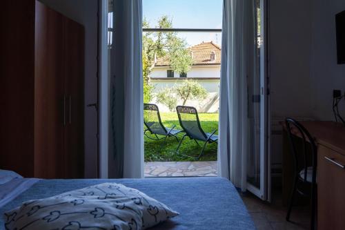a bedroom with a door open to a patio with chairs at Albergo Blueline in Tellaro