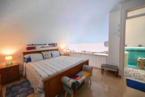 una camera con letto e sedia e un balcone di Beach House Ischia a Ischia