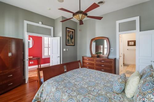 a bedroom with a bed and a ceiling fan at Seaside Creole Cottage in Gulfport