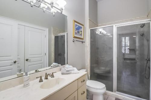 a bathroom with a shower and a sink and a toilet at Seaside Creole Cottage in Gulfport