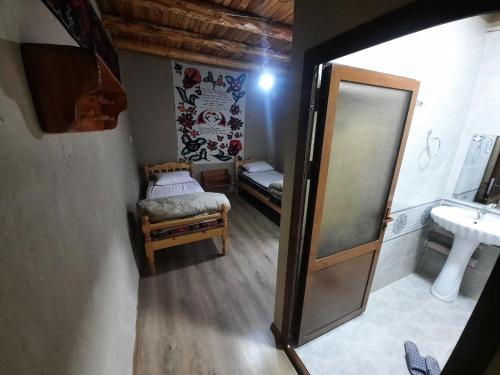 a small room with a bed and a mirror at Ulugbeks guesthouse in Yukary-Ukhum