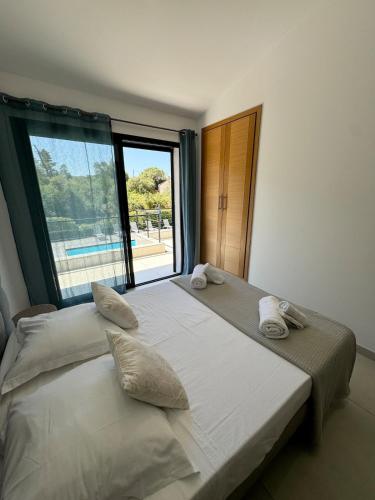 une chambre avec un grand lit avec une grande fenêtre dans l'établissement Villa - Porto-Vecchio - Piscine privée, à Porto-Vecchio