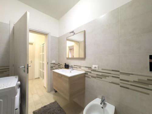 a white bathroom with a sink and a mirror at Appartamento Dolce dimora nel centro storico in Grosseto