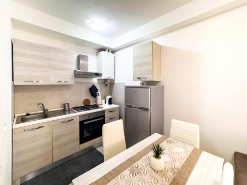 a kitchen with a table and a stove and a refrigerator at Appartamento Dolce dimora nel centro storico in Grosseto