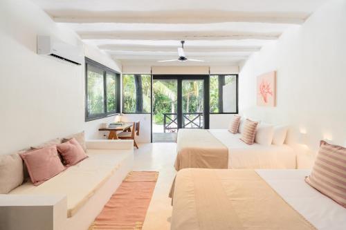 a hotel room with two beds and a couch at Casa Gitano in Tulum