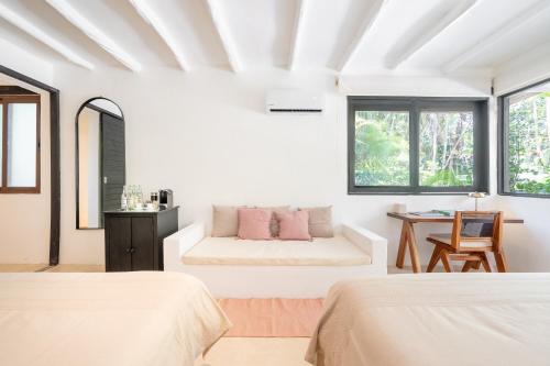 a white room with two beds and a couch at Casa Gitano in Tulum