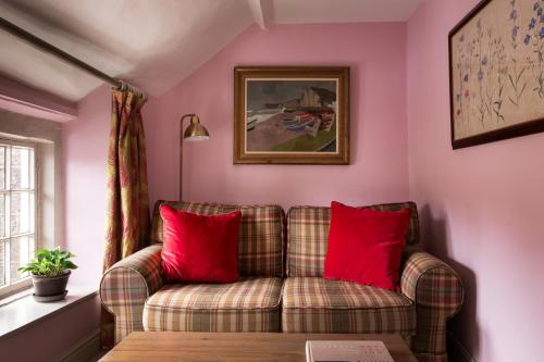 a living room with a couch and red pillows at The Beeley Inn - Chatsworth in Beeley