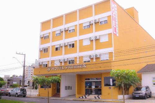 un bâtiment jaune avec un panneau devant lui dans l'établissement Premier Palace Hotel, à Araranguá