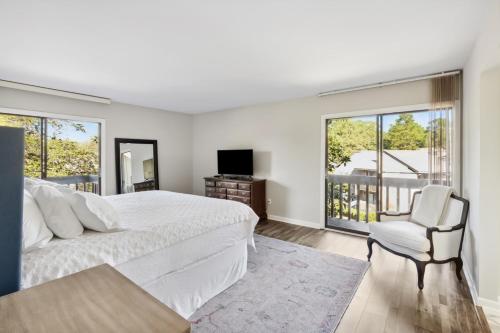 パインハーストにあるPinehurst Tee Time Retreatのベッドルーム1室(ベッド1台、椅子、窓付)