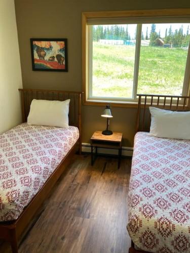 a bedroom with two beds and a window at Moose Ridge Retreat in Gallatin Gateway