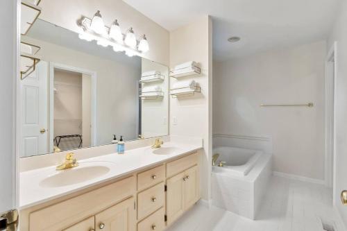 a bathroom with a sink and a mirror and a toilet at Hialeah Hole in One Golf House in Pinehurst