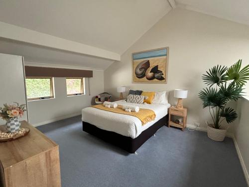 a bedroom with a bed and a plant in it at Belluca Villa, Middleton Beach in Albany