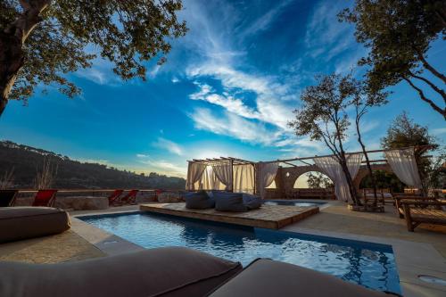 a swimming pool with a couch and a table at Casadar Guesthouse in Ash Shi‘b