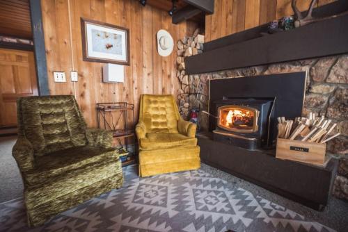 a living room with two chairs and a fireplace at Big Sky Bungalow in Big Sky