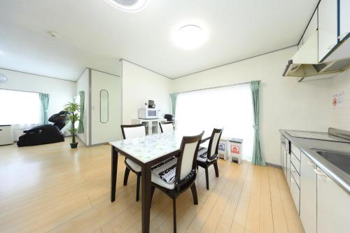 a kitchen and dining room with a table and chairs at サザンコースト湘南 in Chigasaki