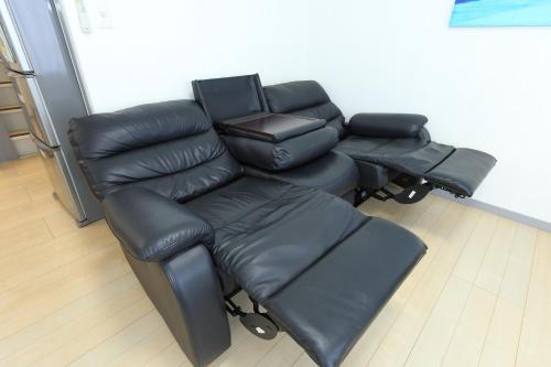 a leather reclining sofa and chair in a room at サザンコースト湘南 in Chigasaki