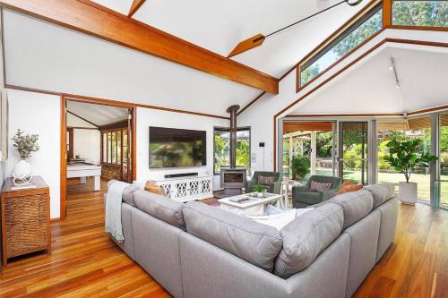 a living room with a large couch and windows at Escape to Darlington Bliss Serene Nature Retreat in Darlington