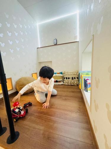 a young child playing with a toy on the floor at 8Home Kids House in Osaka