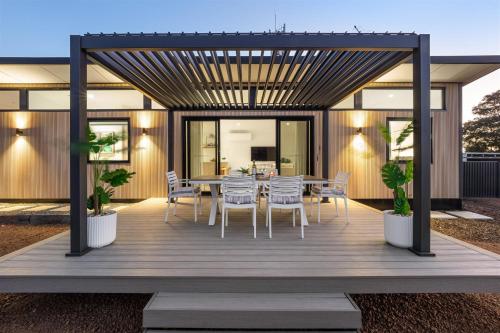 a wooden deck with a table and chairs on it at Cabin 21 - Luxury Wellness Escape - Town Central in Margaret River Town