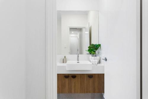 a bathroom with a white sink and a mirror at Spacious and modern Dianella in Perth