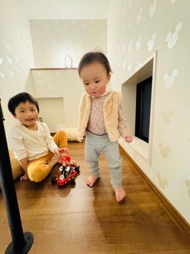 two children playing with a toy on the floor at 8Home Kids House in Osaka