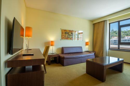 a living room with a couch and a table at Vila Gale Coimbra in Coimbra
