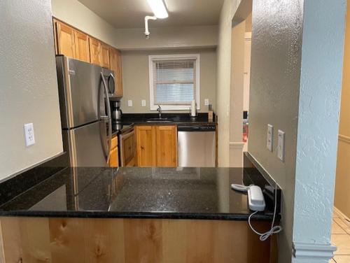 a kitchen with a stainless steel refrigerator and wooden cabinets at Sweetwater Lift Lodge in Park City