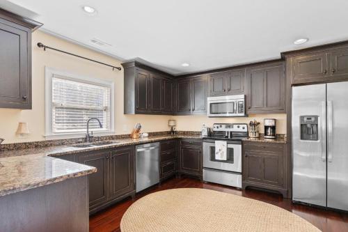 a kitchen with wooden cabinets and stainless steel appliances at The Red Door House in Historic Georgetown in Georgetown