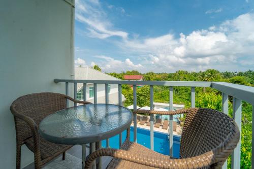 a balcony with a table and chairs and a pool at Villa Amphawa in Amphawa