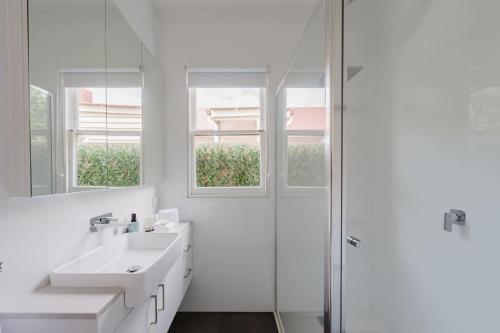 YarravilleにあるNavi Home, stay like localsの洗面台とシャワー付きの白いバスルーム