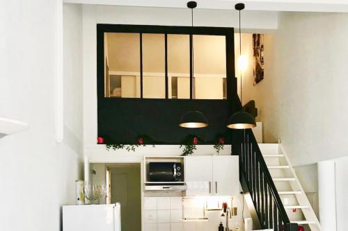 un salon avec un escalier et un four micro-ondes dans l'établissement Loft sous les toits lumineux - Capitole-Daurade-Esquirol - Wifi, à Toulouse