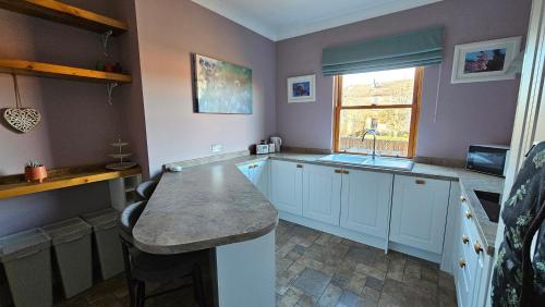 a kitchen with a sink and a counter top at Beautiful self contained apartment with garden in Glasgow