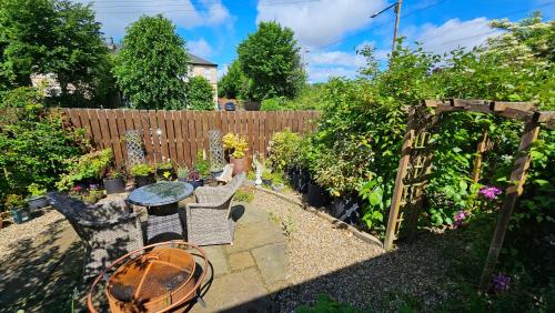 a garden with a table and chairs and a fence at Beautiful self contained apartment with garden in Glasgow