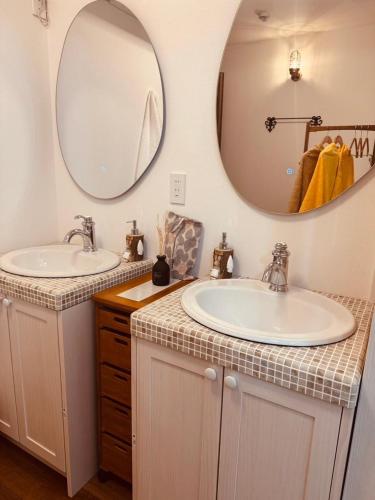 a bathroom with two sinks and a large mirror at 8Home Kids House in Osaka