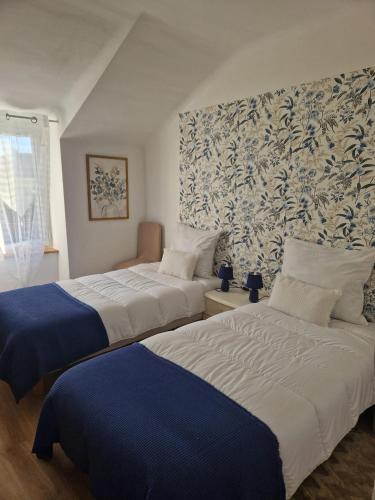 - 2 lits dans une chambre avec papier peint bleu et blanc dans l'établissement Spacieuse villa avec piscine privée à Béganne, à Béganne